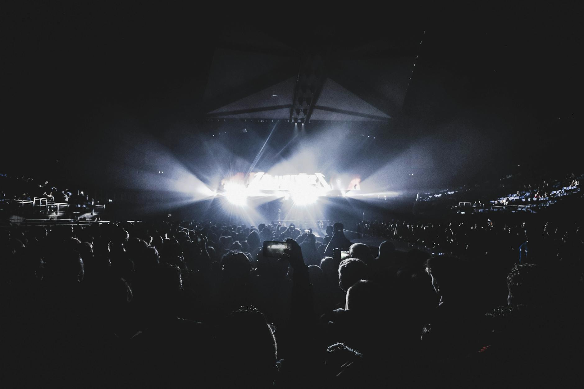 Crowd watching a show inside a dark stadium